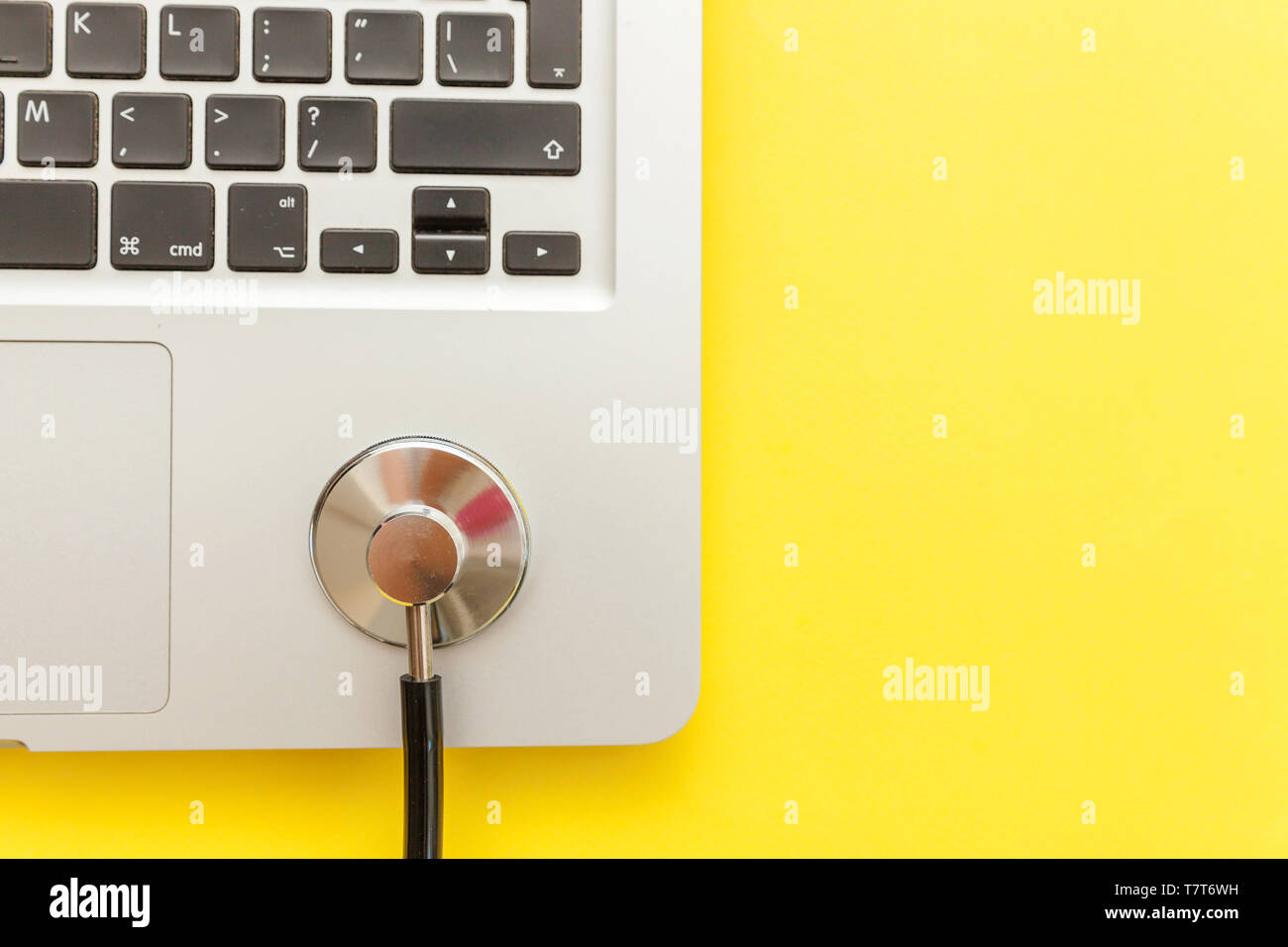 Uno stetoscopio tastiera computer portatile isolato su sfondo giallo.  Moderna tecnologia dell'informazione medica e sofware avanza concetto.  Computer e gadget di diagnostica e riparazione. Appartamento laici vista  superiore Foto stock - Alamy