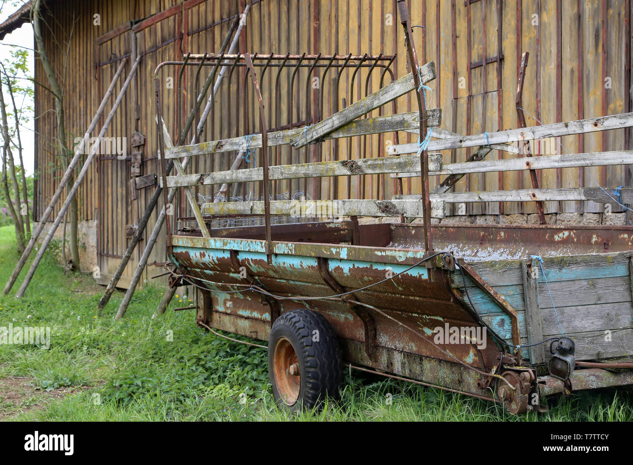 Vecchio trattore carrello sorge in un granaio in legno. Foto Stock