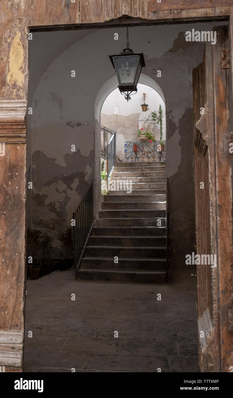 Porta in legno che conduce ad una scala di pietra nel centro storico di Cefalù, Sicilia. Foto Stock