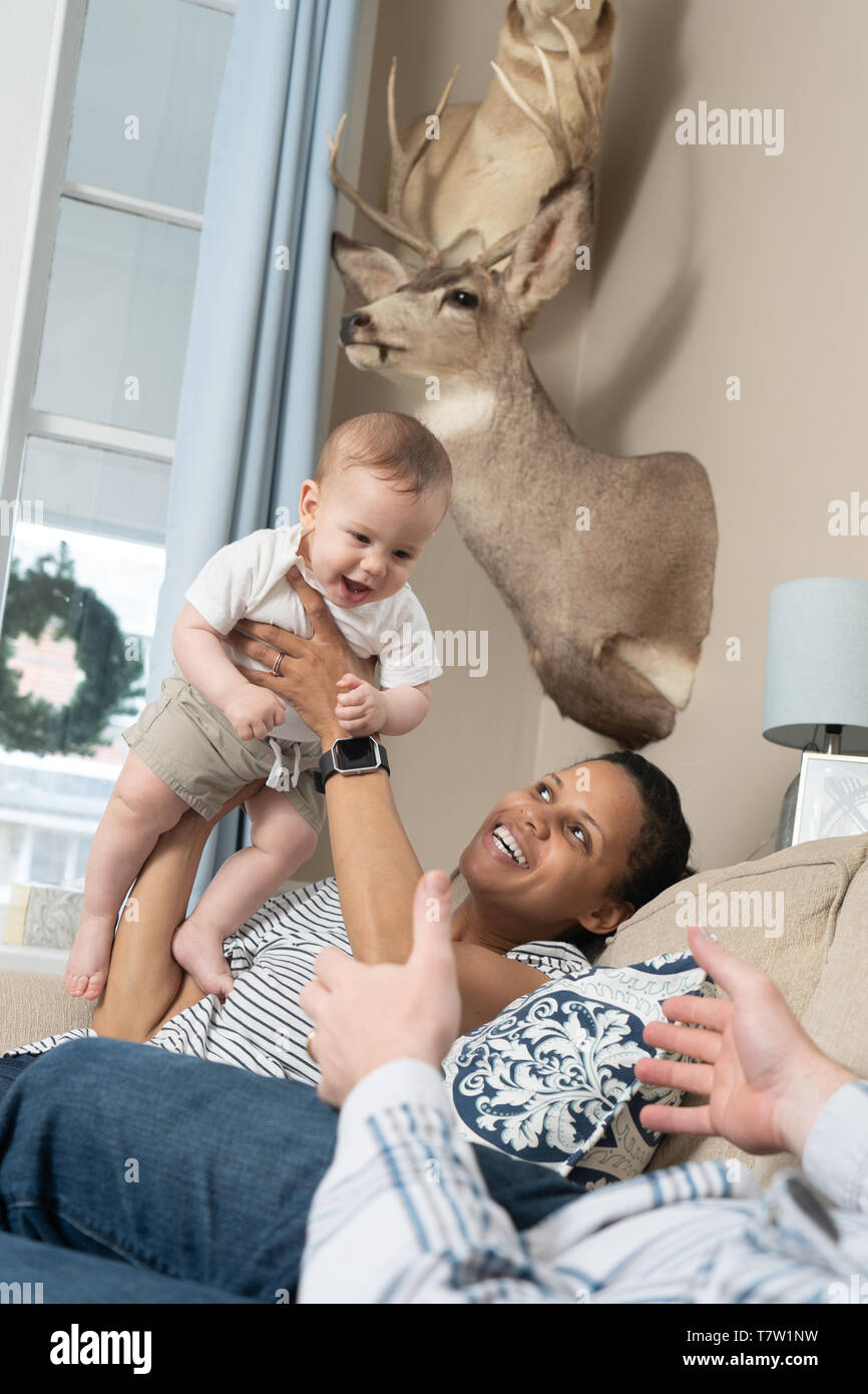 I genitori di riproduzione con il suo bambino di 6 mesi nella loro casa nel nord di Philadelphia Foto Stock