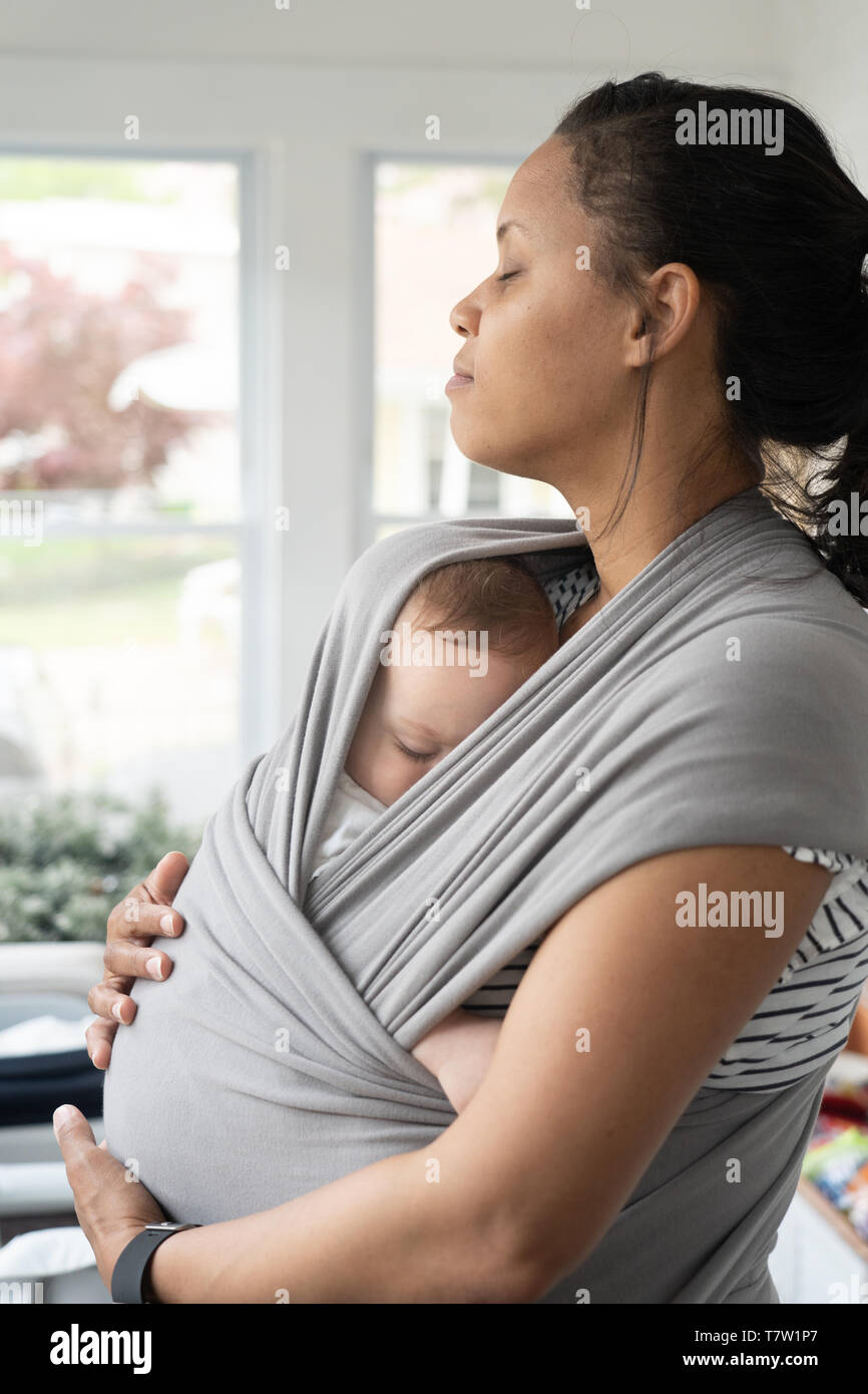 La madre trattiene il suo bambino (6 mesi di età) nella sua casa nel nord di Philadelphia Foto Stock