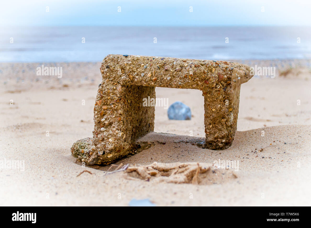 Brezza di mare - Un eroso blocco di calcestruzzo su una spiaggia in NORFOLK REGNO UNITO. Foto Stock