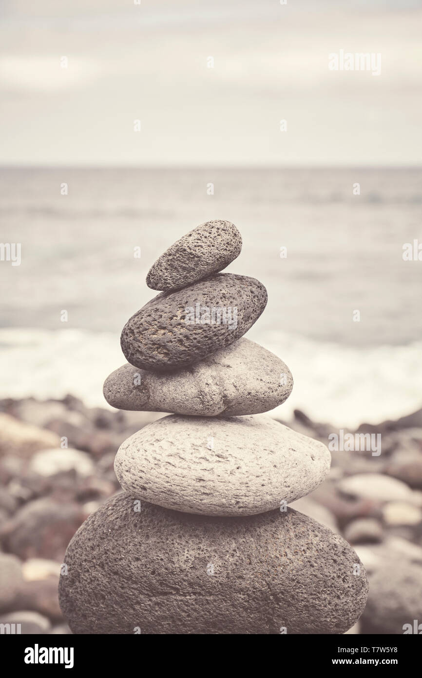 Nei toni del colore dell'immagine di una pila di pietra su una spiaggia, equilibrio e armonia concetto, il fuoco selettivo. Foto Stock