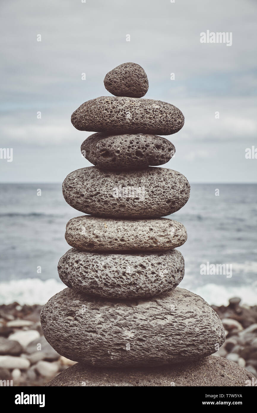 Nei toni del colore dell'immagine di una pila di pietra su una spiaggia, equilibrio e armonia concetto, il fuoco selettivo. Foto Stock