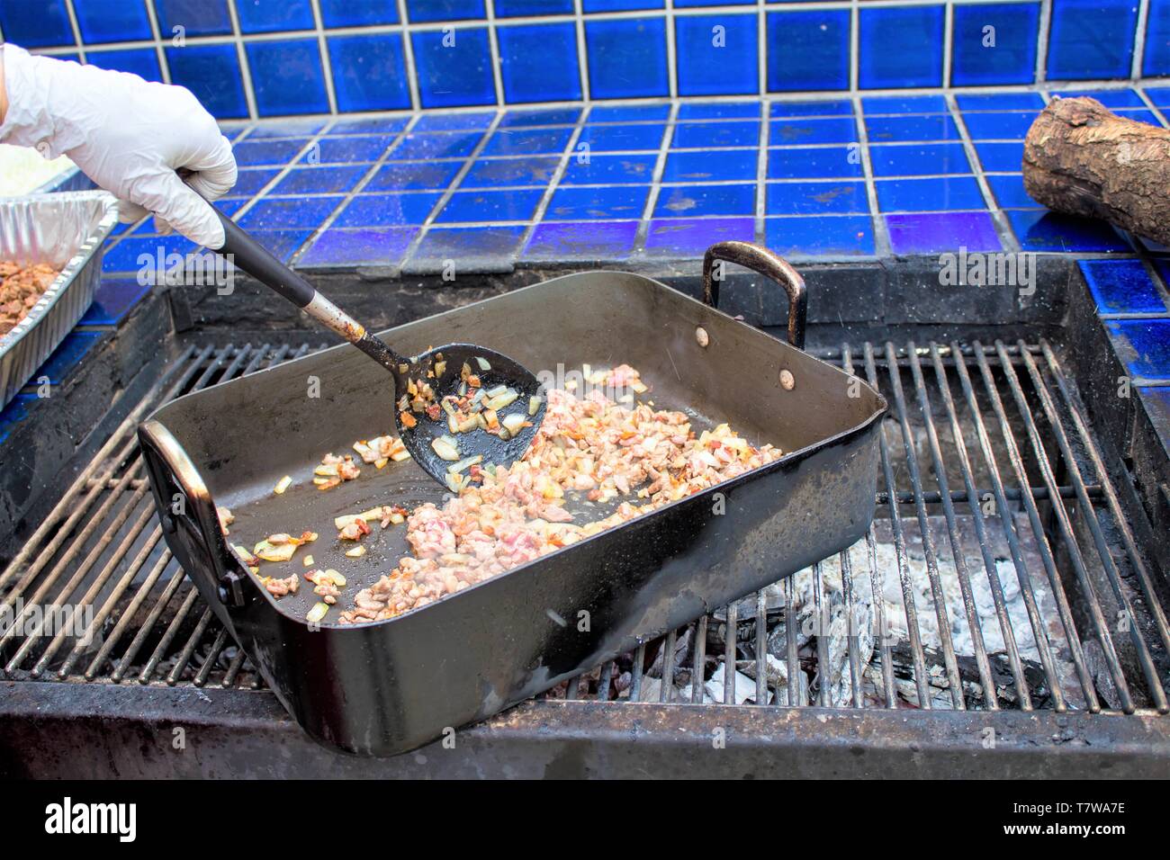 Mano che tiene la spatola su barbeque Foto Stock