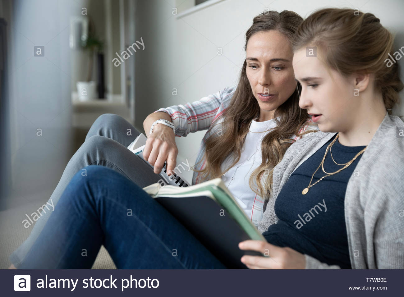 Madre aiutare figlia adolescente con i compiti Foto Stock