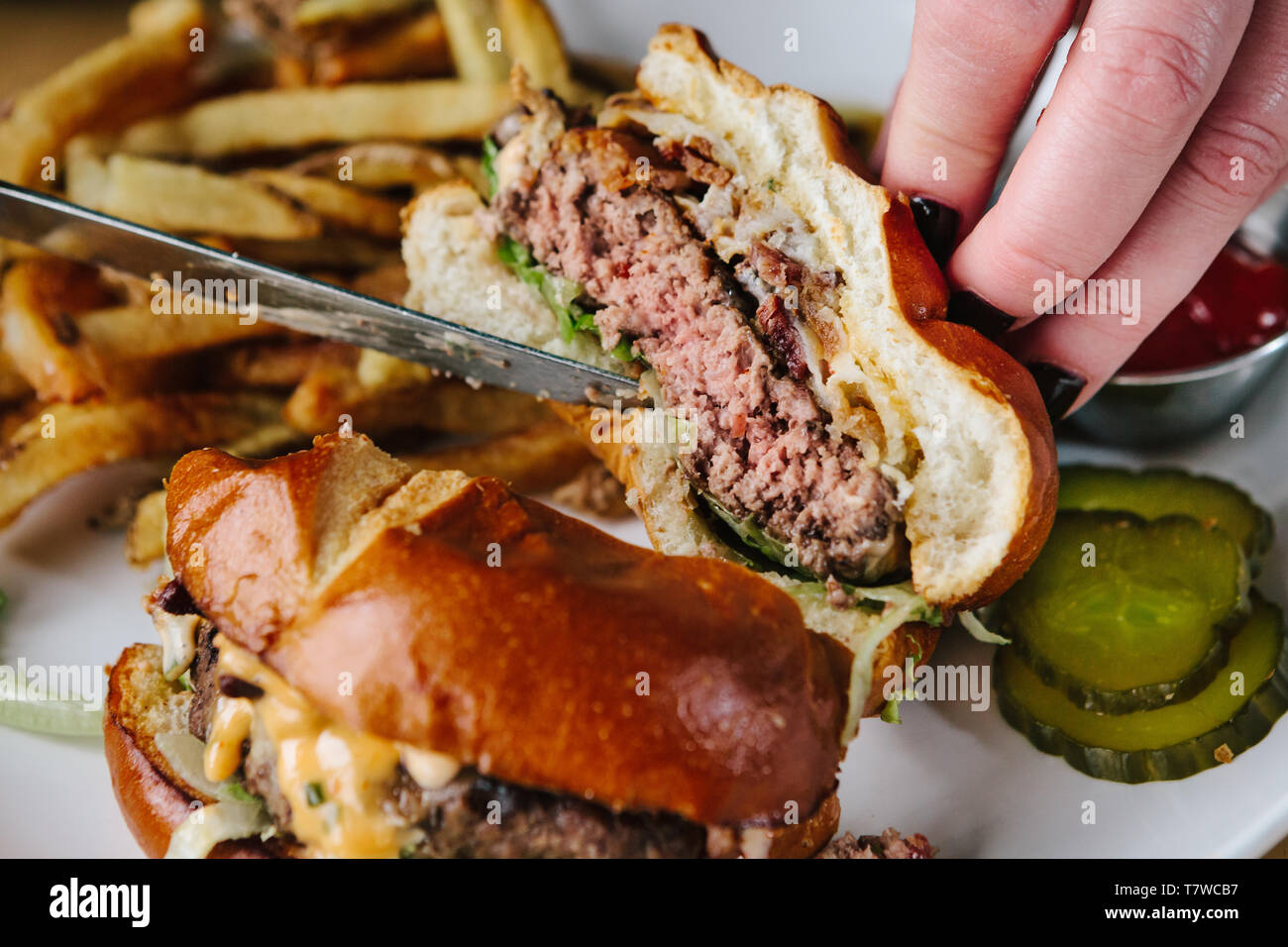 Cheeseburger con patatine fritte, placcato in qualità di ristorante Foto Stock