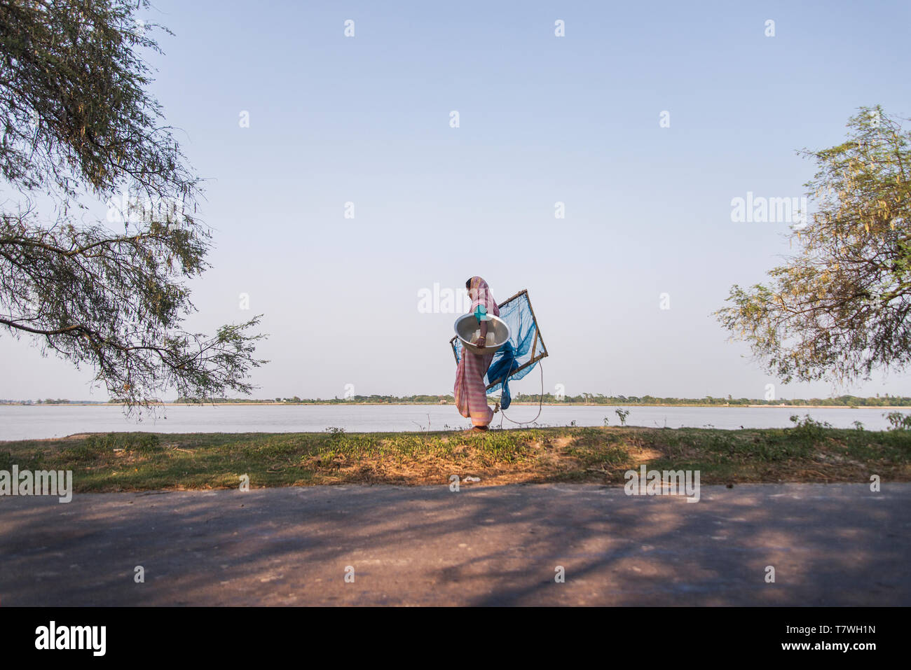 Fisherman porta una rete da pesca in Khulna, Bangladesh. Foto Stock
