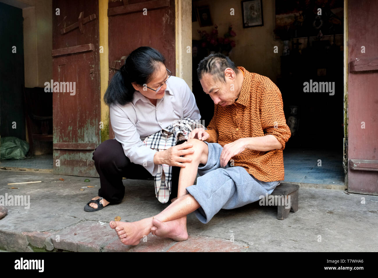 La Chiesa cattolica suor Marie Binh (55) appare dopo che l'agente Orange vittima Minh Nguyen lungo (64), che vive con il suo prossimo. L'unità PHU Ly village (Ha Nam provincia) vicino a Hanoi, Vietnam Foto Stock