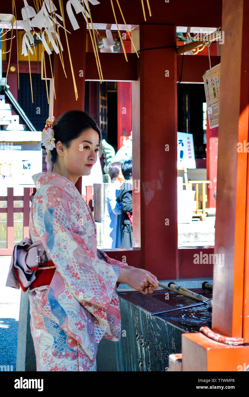Una donna facendo il cerimoniale di rito di purificazione nel chōzuya temizuya o. Sensō-ji. Asakusa, Tokyo, Giappone. Foto Stock