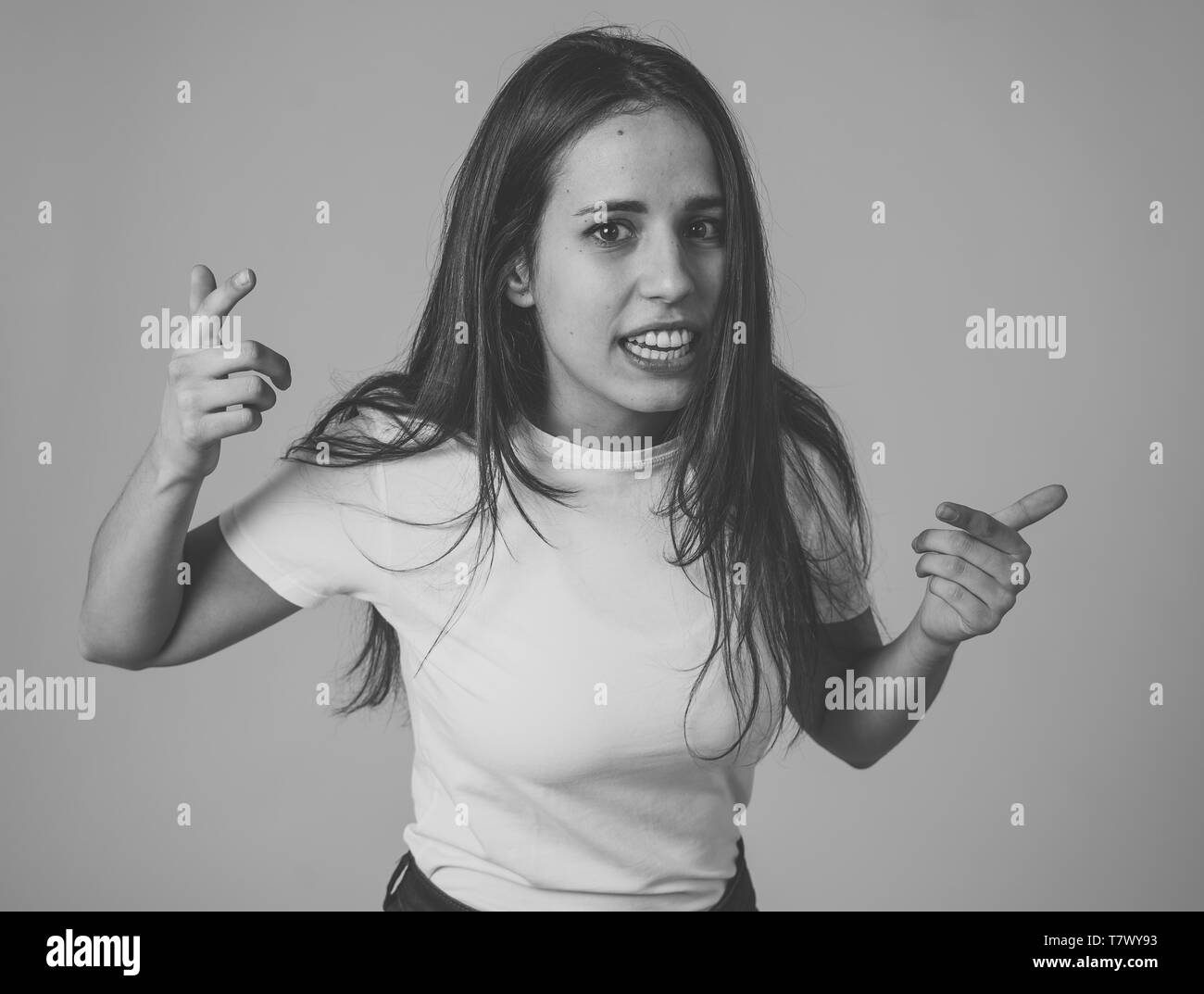 Close up di giovani frustrati attraente donna latina nel sottolineare con la furiosa faccia. Guardando mad e deluso compiendo gesti arrabbiato. In backgr neutrale Foto Stock