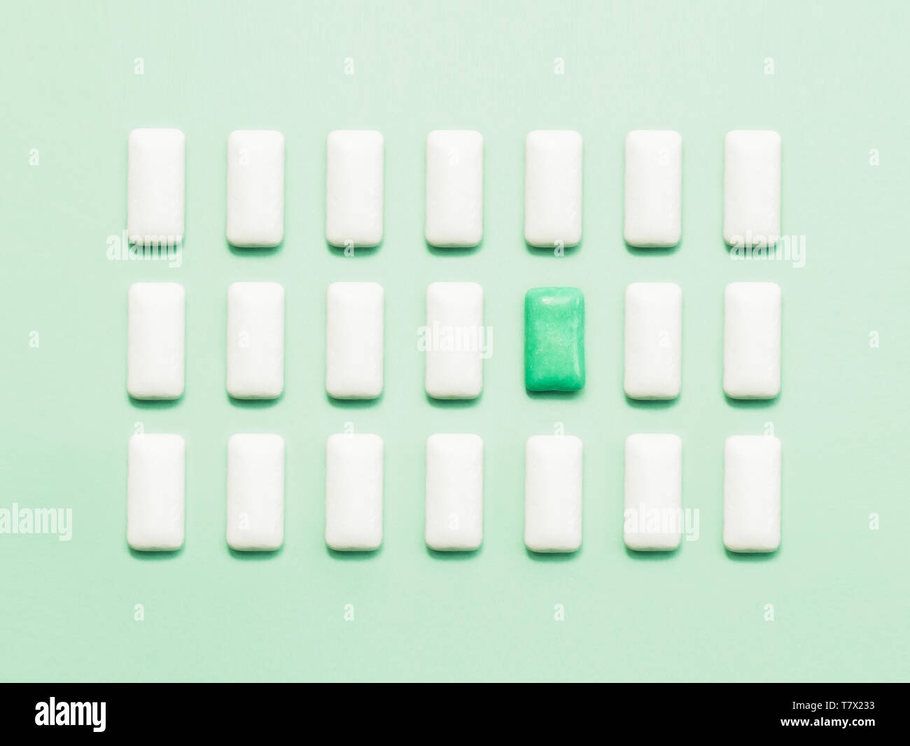 Verde di una gomma da masticare in piedi fuori di bianco le gomme da masticare. Concetto di individualità e unicità o solitudine, sociali emarginati. Foto Stock