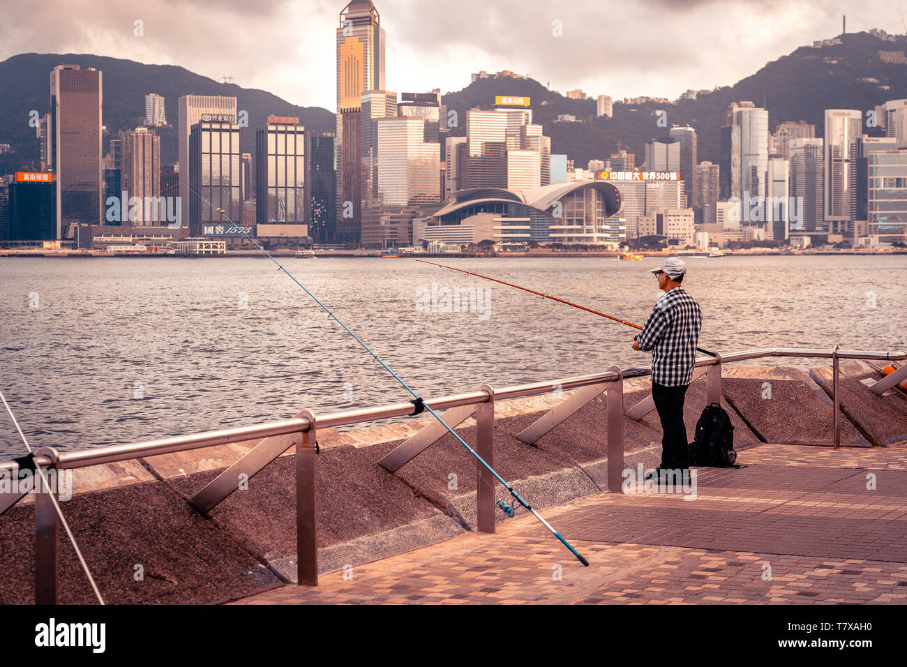 Hong Kong Cina - vecchio uomo la pesca nel porto Foto Stock