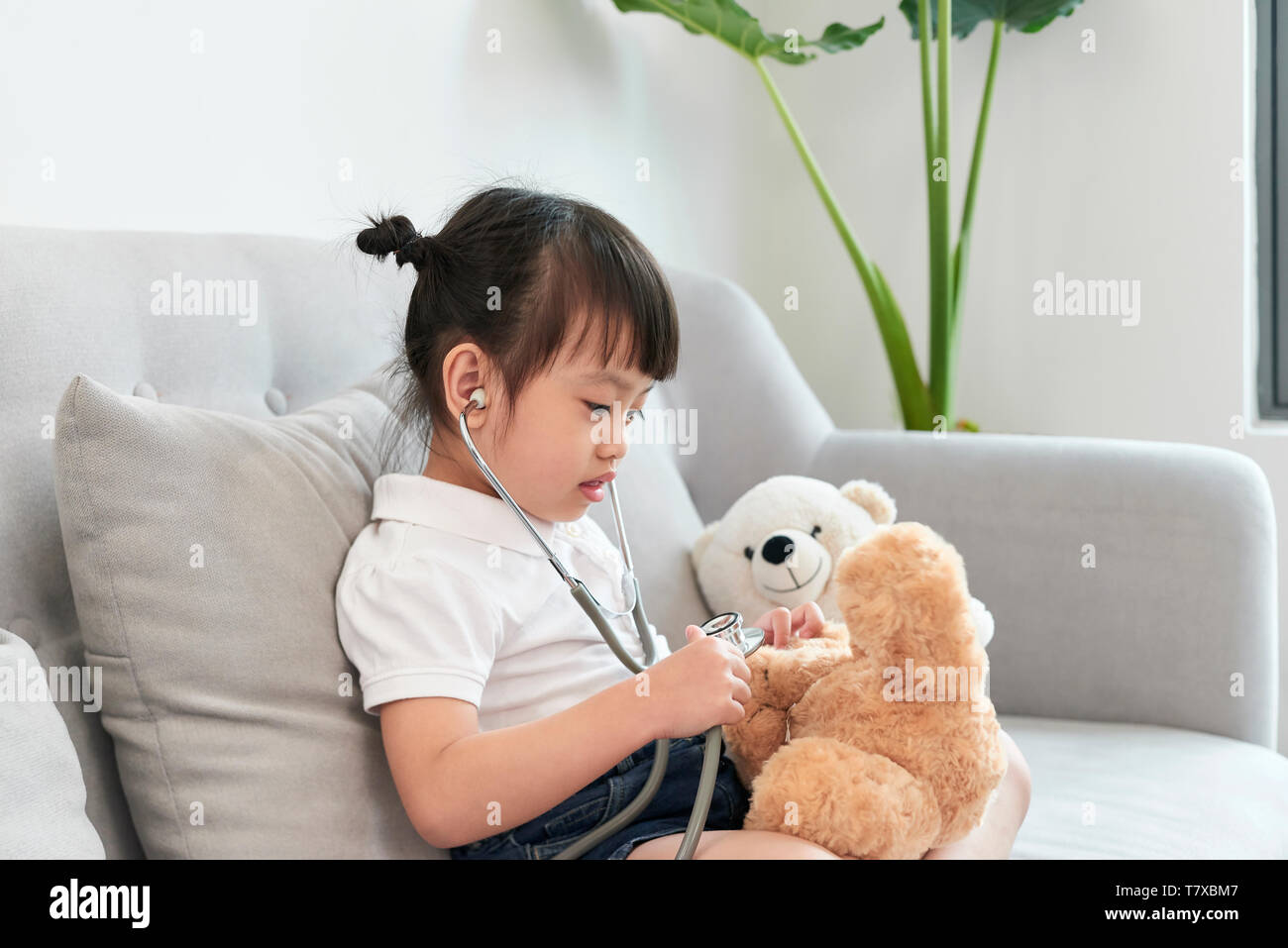 Un medico ragazza la riproduzione e la cura di recare in pazienti pediatrici Foto Stock