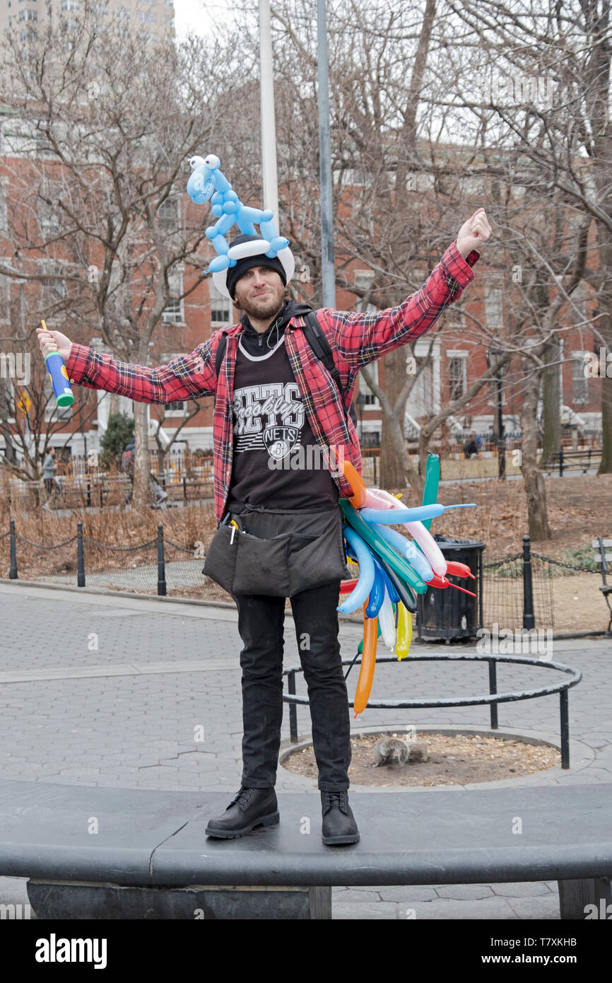 Poste ritratto di un giovane uomo che vende palloncini piegate in forme animali. In Washington Square Park, Greenwich Village di New York City. Foto Stock
