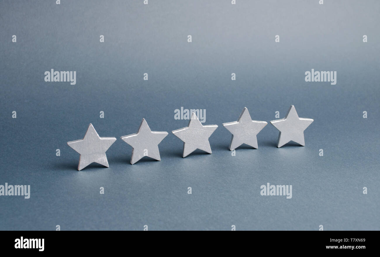 Cinque stelle su sfondo grigio. Il concetto di rating e valutazione. La valutazione dell'albergo, ristorante, applicazione mobile. Il servizio di qualità, acquirente Foto Stock