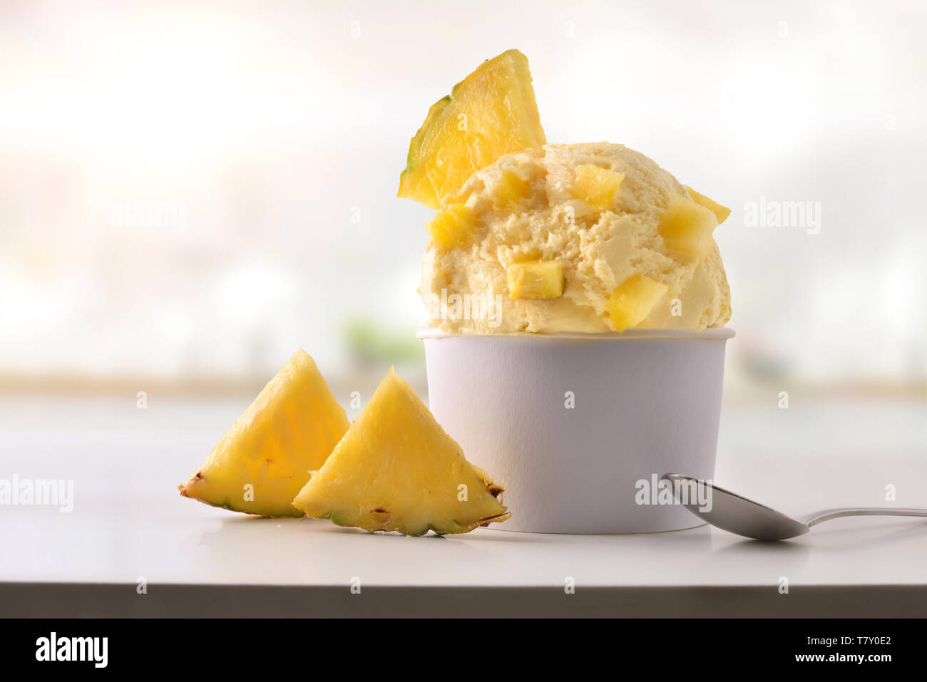 Ananas coppa di gelato sul tavolo bianco in casa con la cucina dello sfondo. Composizione orizzontale. Vista frontale. Foto Stock