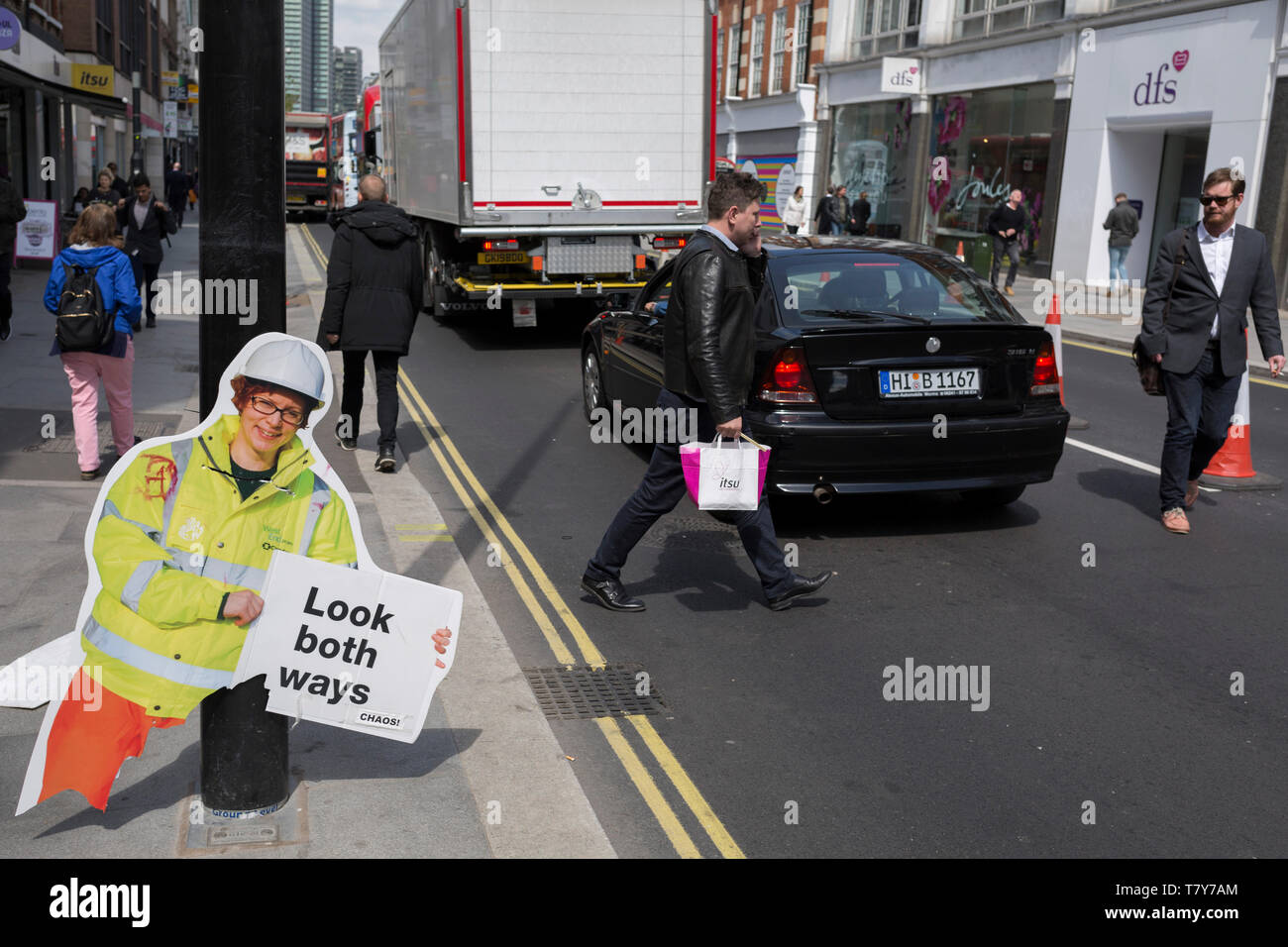 La rottura di una costruzione di avvertimento opera figura - uno dei molti verso l'alto e verso il basso su entrambi i lati del Tottenham Court Road, avverte i pedoni di una modifica del layout della strada, da uno a due vie di traffico, il 7 maggio 2019, a Londra, in Inghilterra. Foto Stock