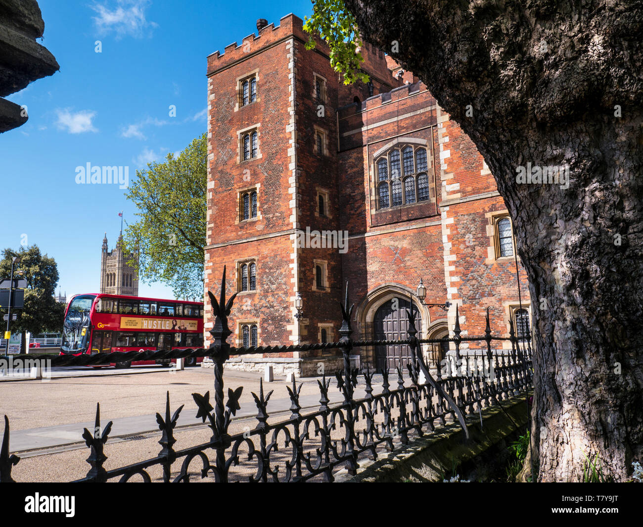 Lambeth Palace di Londra. Morton's Tower con il Parlamento e il rosso London bus. Mattone rosso Tudor gatehouse formante l'ingresso al Lambeth Palace London REGNO UNITO Foto Stock
