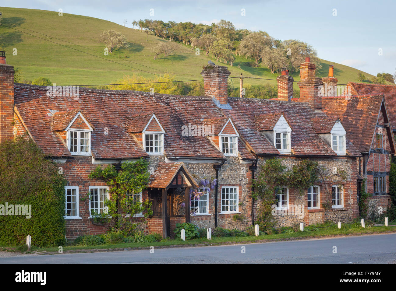 Tradizionale in mattoni e pietra focaia cottages nel villaggio di Turville, Buckinghamshire con Turville collina alle spalle. Foto Stock
