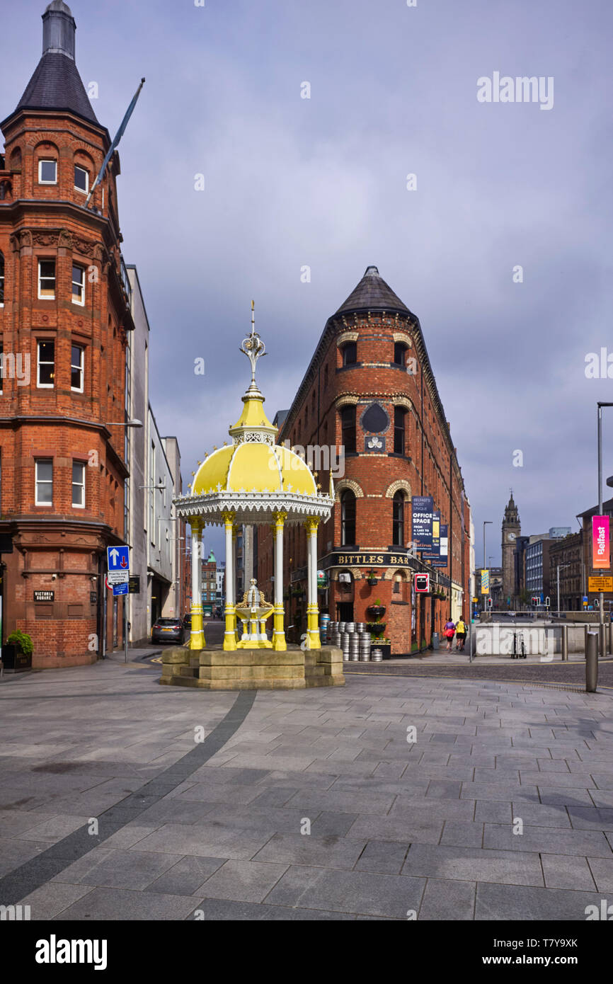 La fontana in ghisa 1870s a Victoria Square Belfast commemora la vita di Daniel Jaffe con il flatiron Shape Bittles Bar sullo sfondo Foto Stock