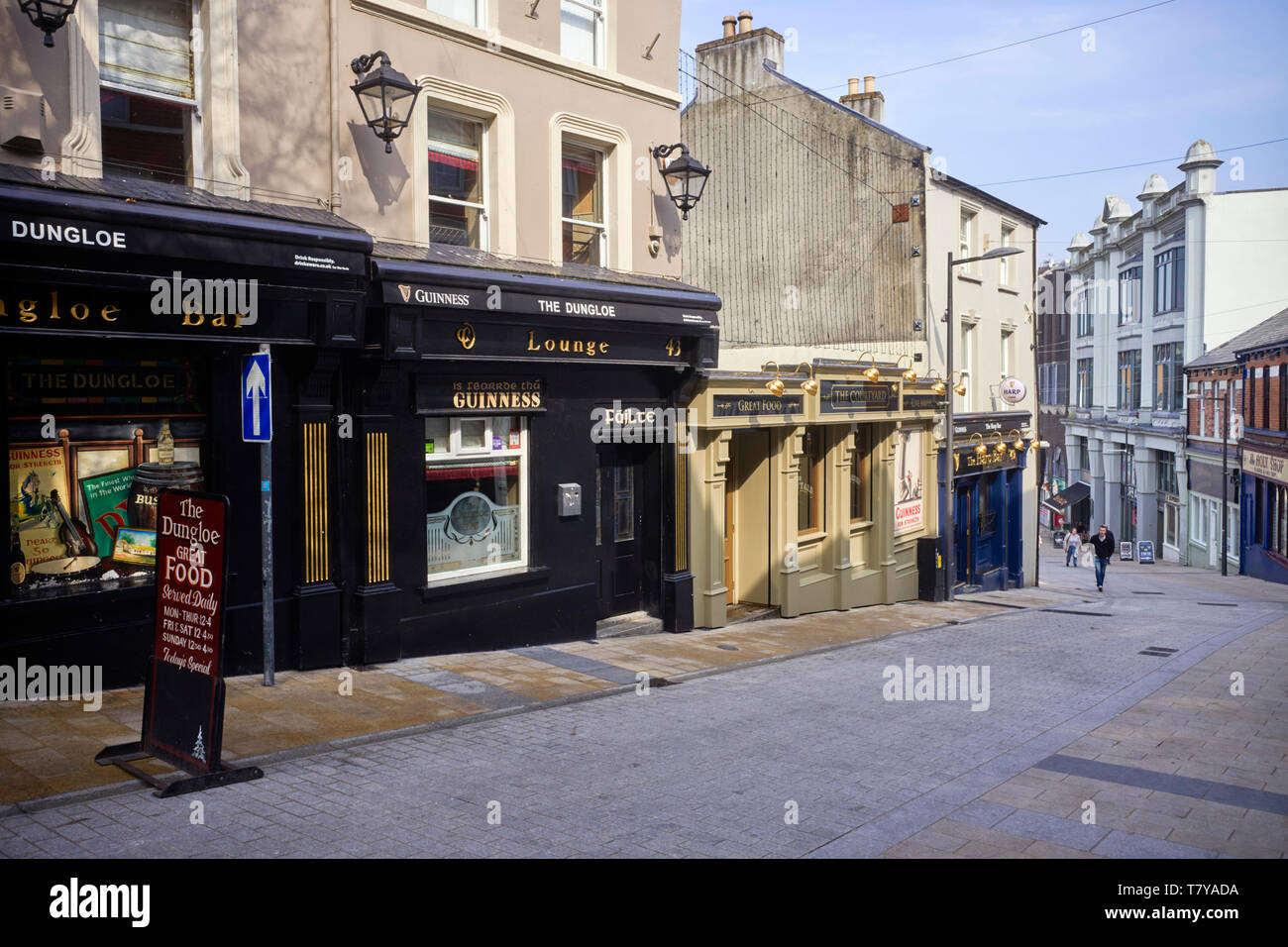 Il ripidamente inclinate Waterloo Street con tre pub in una riga a Londonderry, Irlanda del Nord Foto Stock