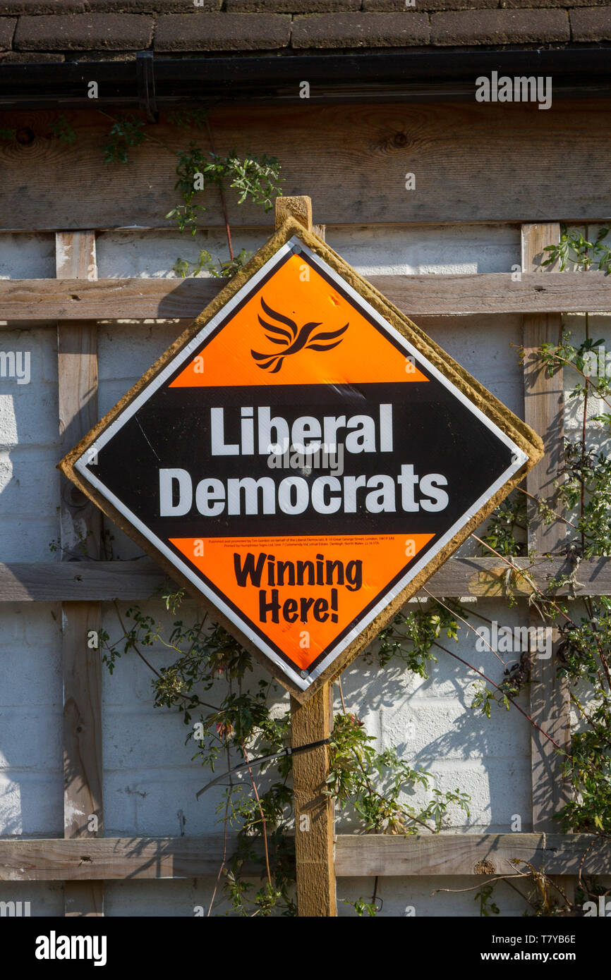 Un arancione e nero Cartellone elettorale per i liberali democratici alle elezioni locali a leggere 'vincere qui". Foto Stock