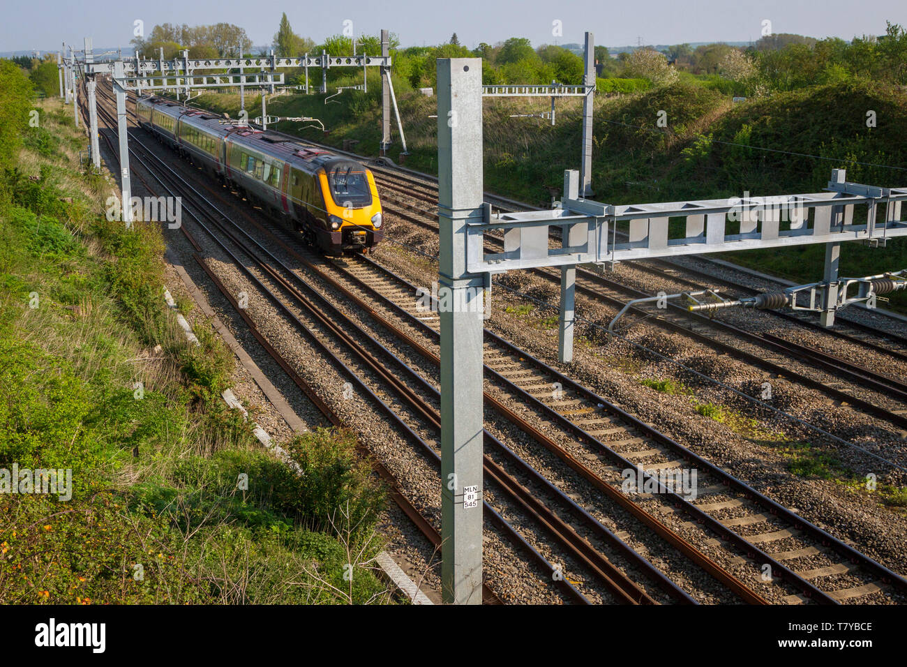 Sovraccarico di nuovo la linea elettrica di portali sulla rete ferroviaria vicino a Goring Oxfordshire con Virgin treno. Foto Stock