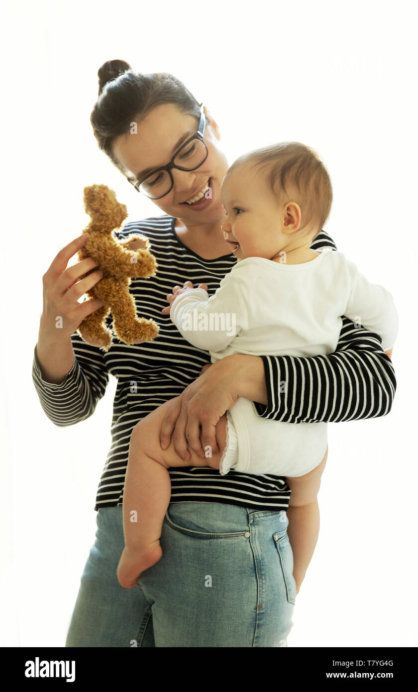 Giovane madre mentre tiene il suo bambino in braccio Foto Stock