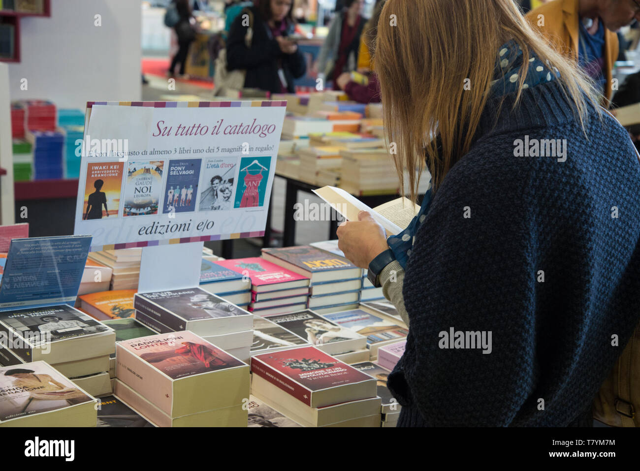 Un visitatore vede la lettura di un libro durante la trentaduesima edizione della fiera. La fiera internazionale del libro è la più importante manifestazione italiana nel campo dell'editoria. Esso avrà luogo presso il centro congressi Lingotto Fiere di Torino una volta all'anno, nel mese di maggio. Foto Stock