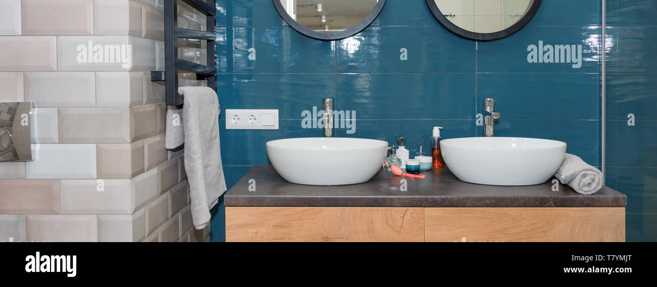 Moderno bagno interno con un ripiano in legno, due lavandini in piedi su di esso e round specchi. In vetro trasparente di cabina doccia, minimalista scandinavo Foto Stock