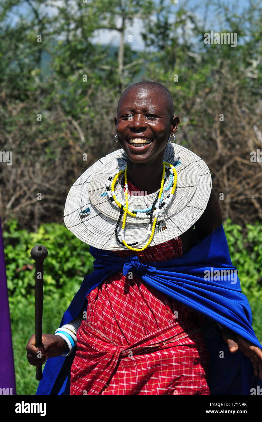 Donna Maasai che indossa abiti colorati e intricati gioielli di collana cereronial tipo bib con perline durante la tradizionale danza di salto Foto Stock