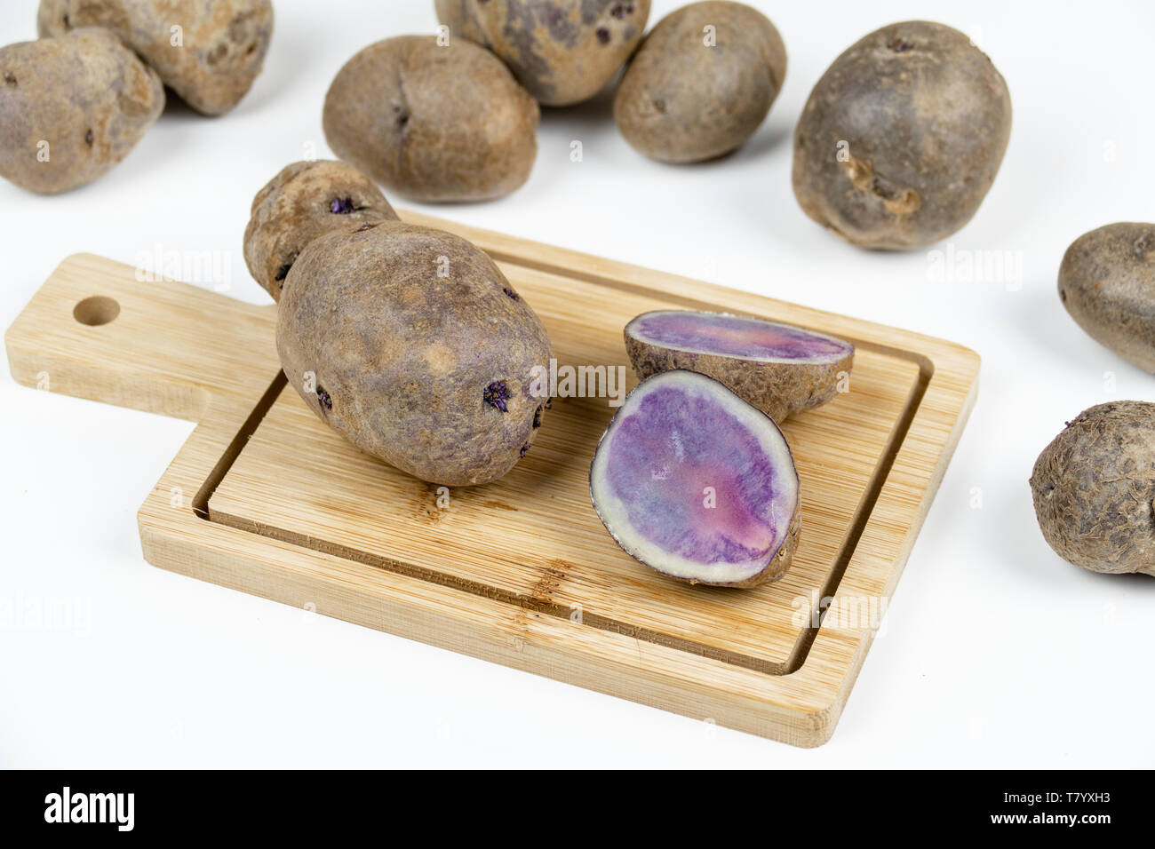 Patate rosse tubero isolato sul tagliere con sfondo bianco Foto Stock