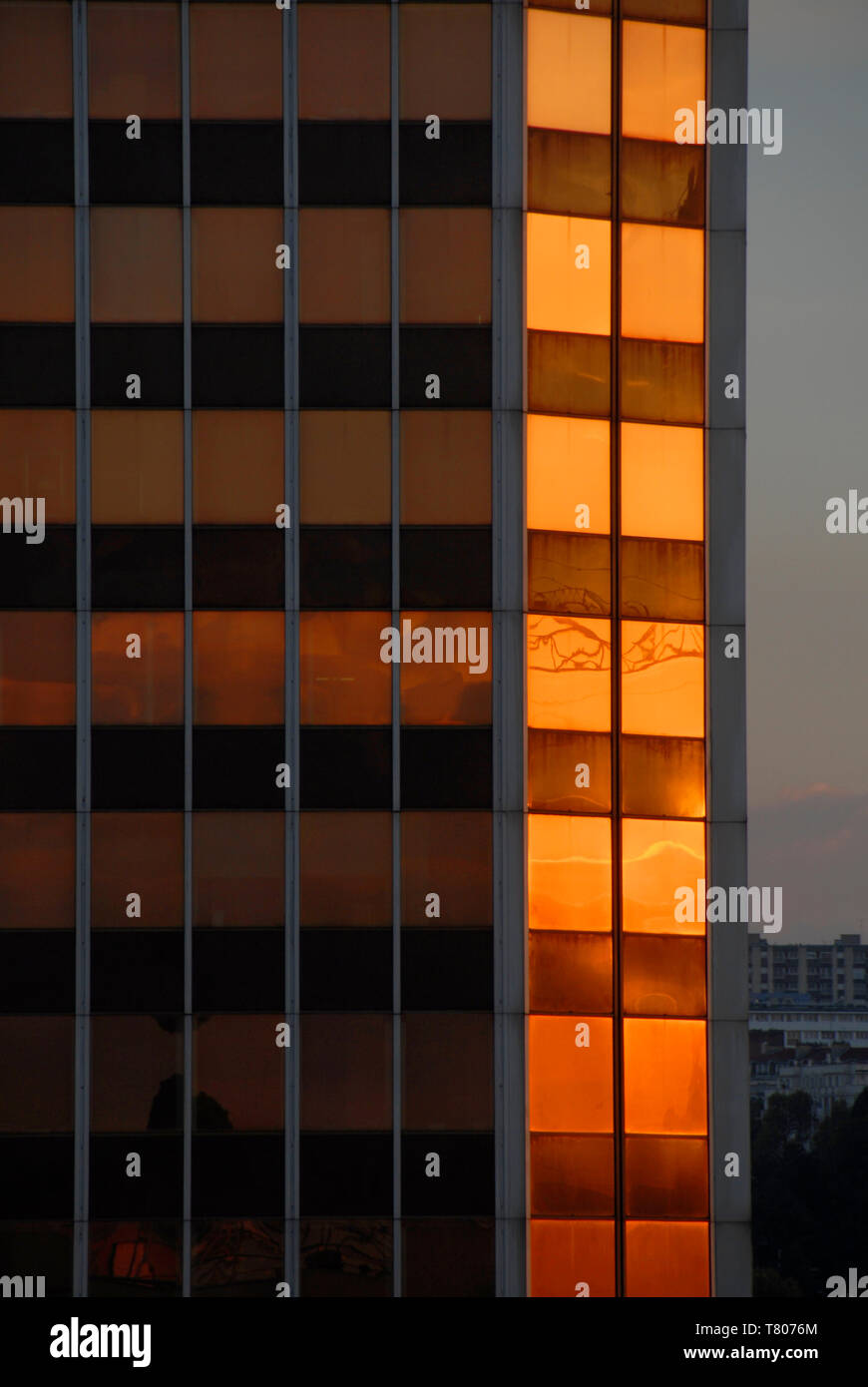 La riflessione della luce della sera in finestre di vetro alto-di fronte edificio per uffici, Parigi, Francia Foto Stock