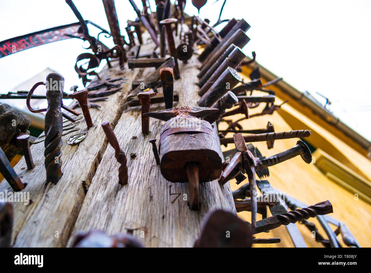 Close up di un alto palo di legno (Journeymen pilastro) con ferro/chiodi in acciaio imbullonata in essa come un simbolo di artigianalità da diverse corporazioni commerciali. Turi Foto Stock