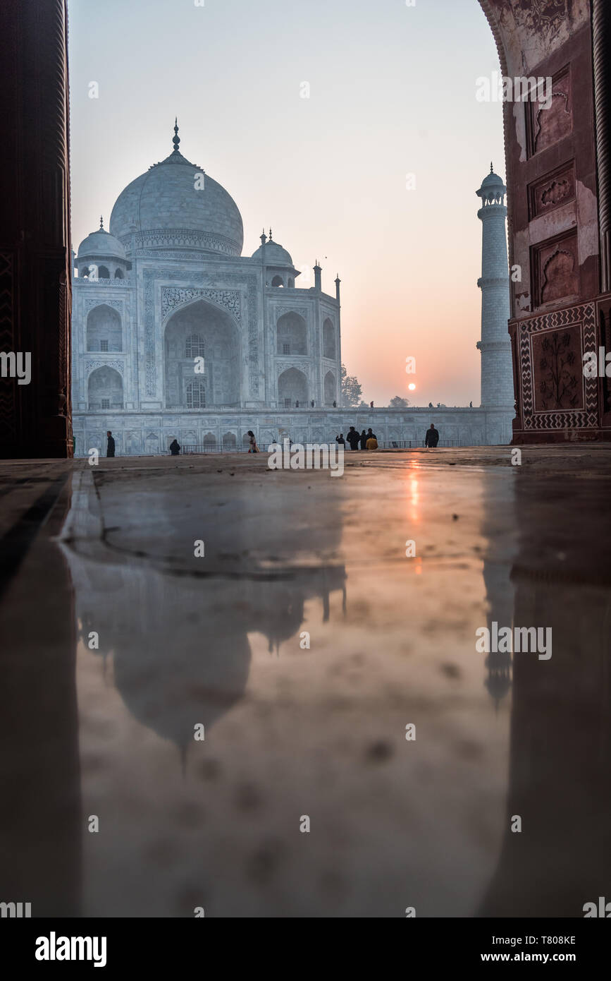 Riflessioni come il sole sorge dietro il Taj Mahal, Sito Patrimonio Mondiale dell'UNESCO, Agra, Uttar Pradesh, India, Asia Foto Stock