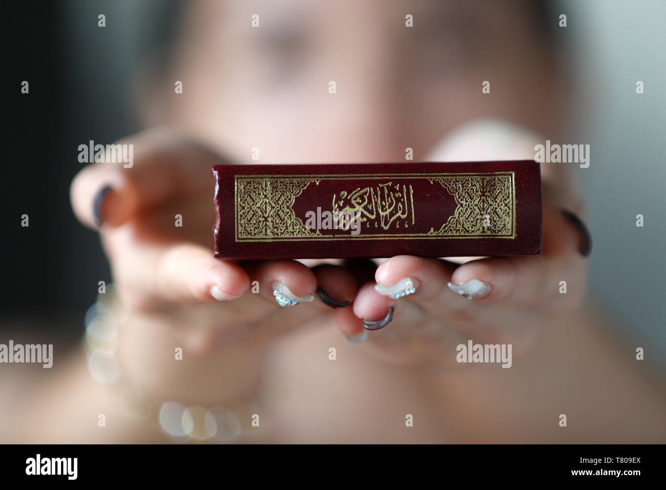 Donna musulmana tenendo premuto il Santo Corano prenota, Indocina, Asia sud-orientale, Asia Foto Stock