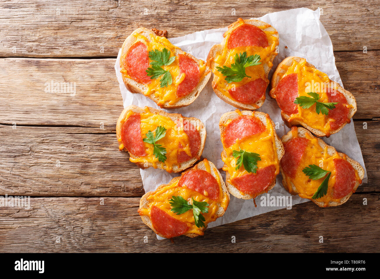 Sandwich caldi con salsiccia e fuso il formaggio cheddar vicino sul tavolo. parte superiore orizzontale vista da sopra Foto Stock