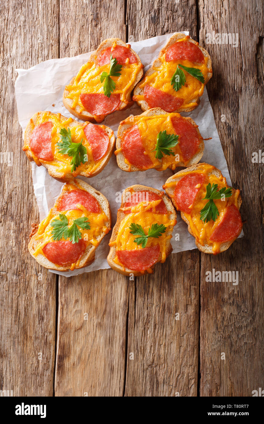 Sandwich caldi con salsiccia e fuso il formaggio cheddar vicino sul tavolo. Verticale in alto vista da sopra Foto Stock
