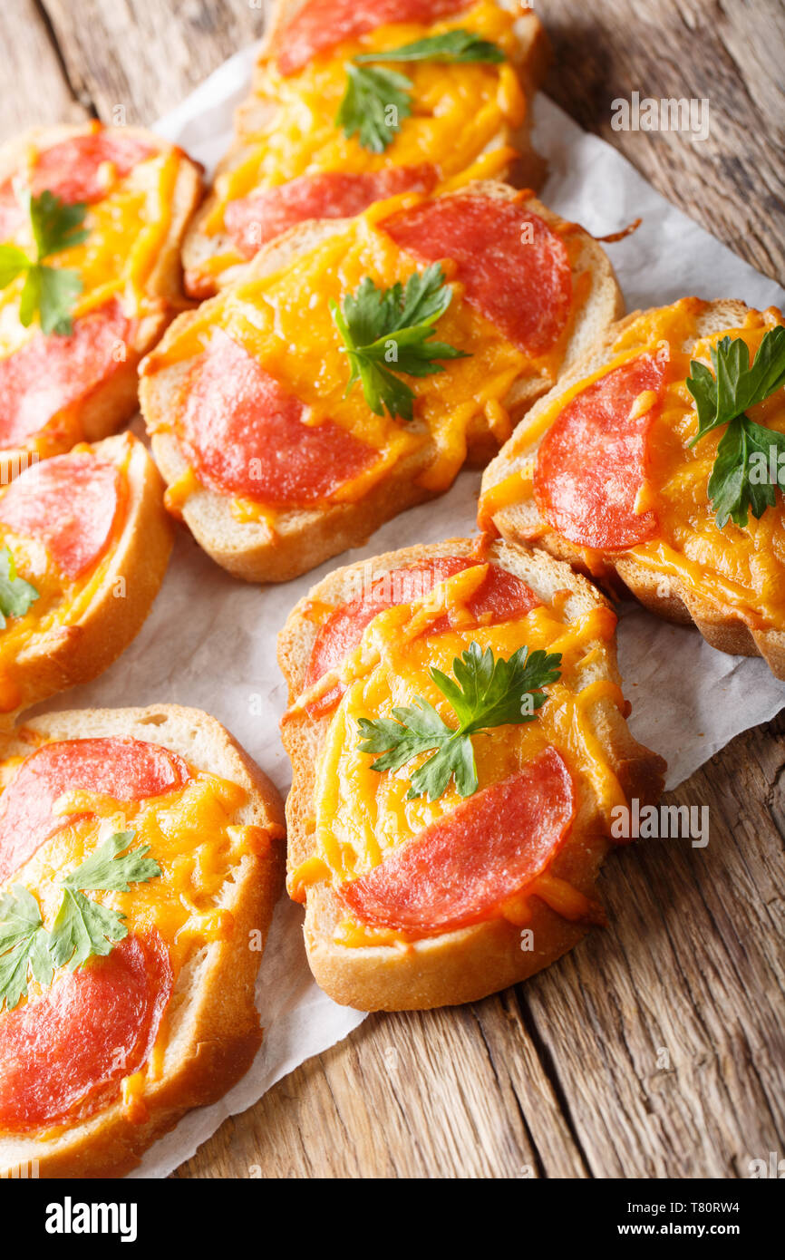 Hot toast al forno con salsiccia e formaggio fuso formaggio cheddar closeup sul piano verticale. Foto Stock