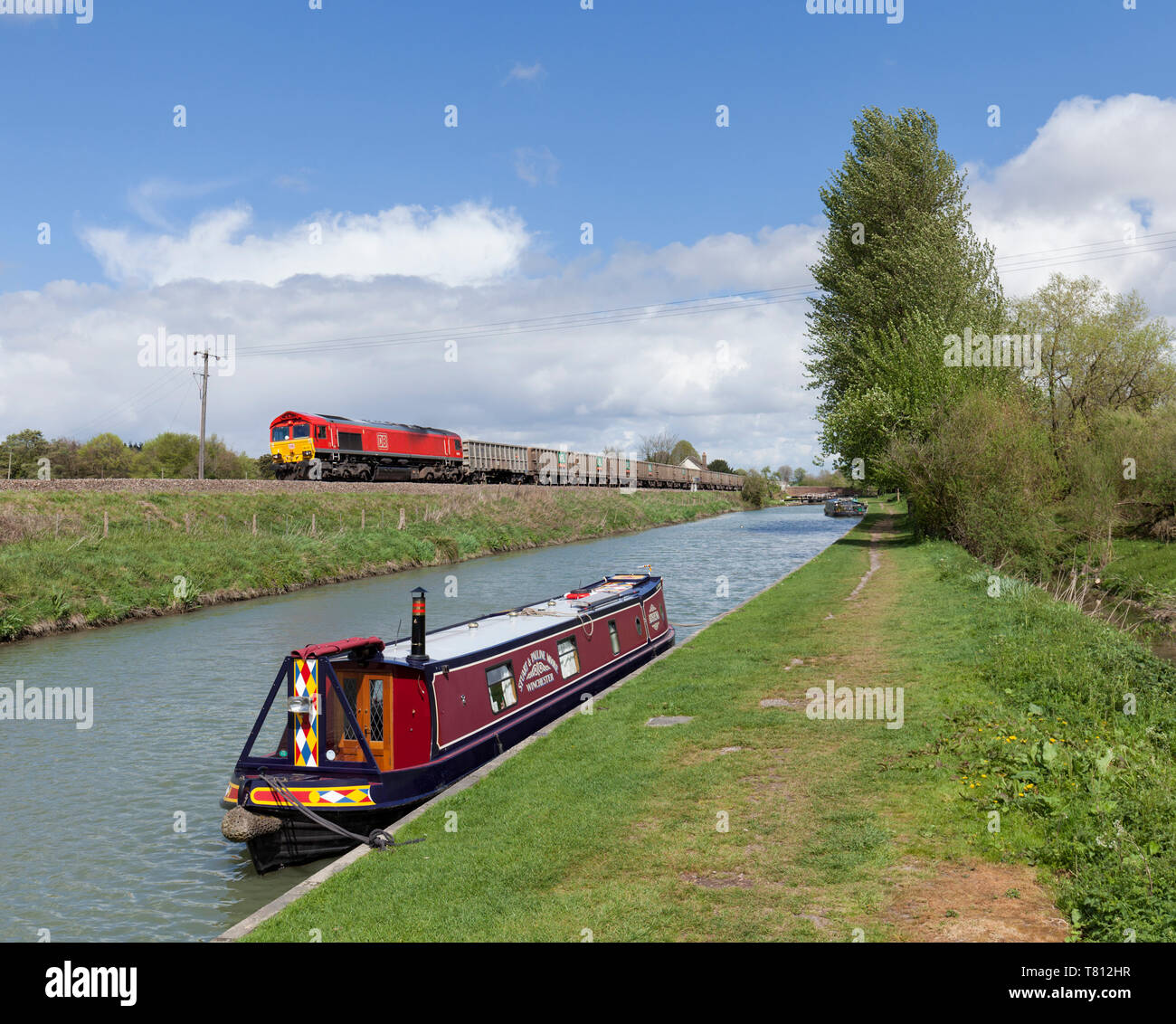 DB Cargo classe 66 locomotiva diesel passando il Kennet and Avon canal a Crofton, Wiltshire con un treno merci di aggregato a vuoto dei carri Foto Stock