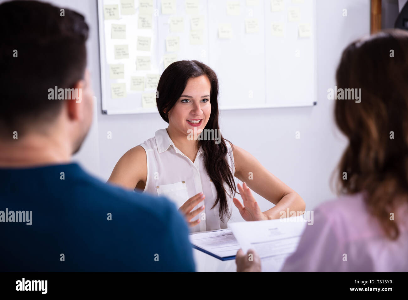Imprenditore e imprenditrice tenendo intervista della giovane donna sorridente Foto Stock