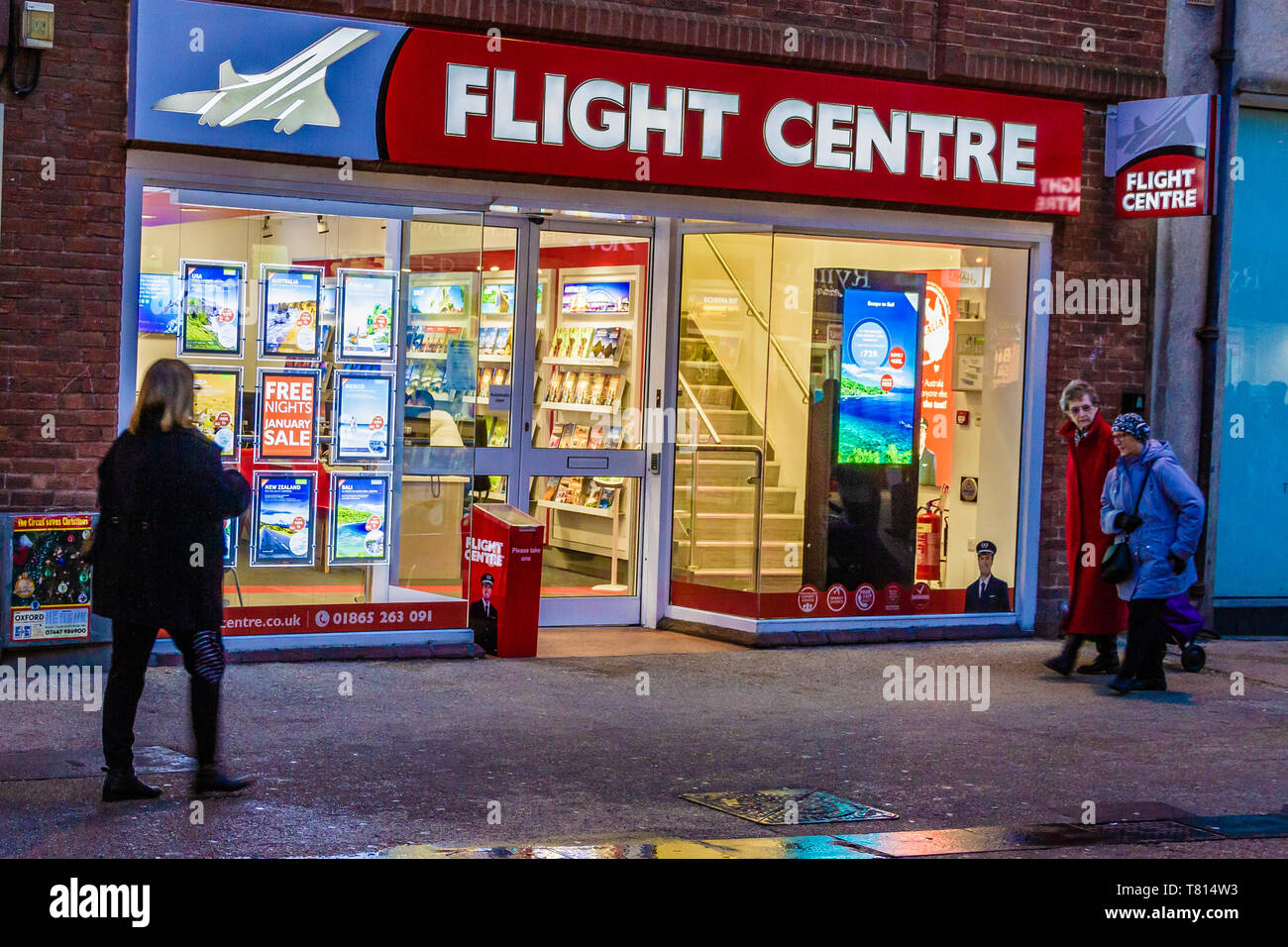 Persone che passano il negozio di fronte esterno di un Centro di Volo agenzia di viaggi, Queen St, Oxford, UK. Dicembre 2018. Foto Stock