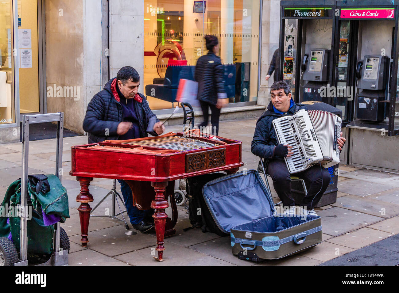 Due musicisti di strada musicista di strada con una fisarmonica ed un cimbalom o dulcimer in Cornmarket Street, Oxford, UK. Dicembre 2018. Foto Stock