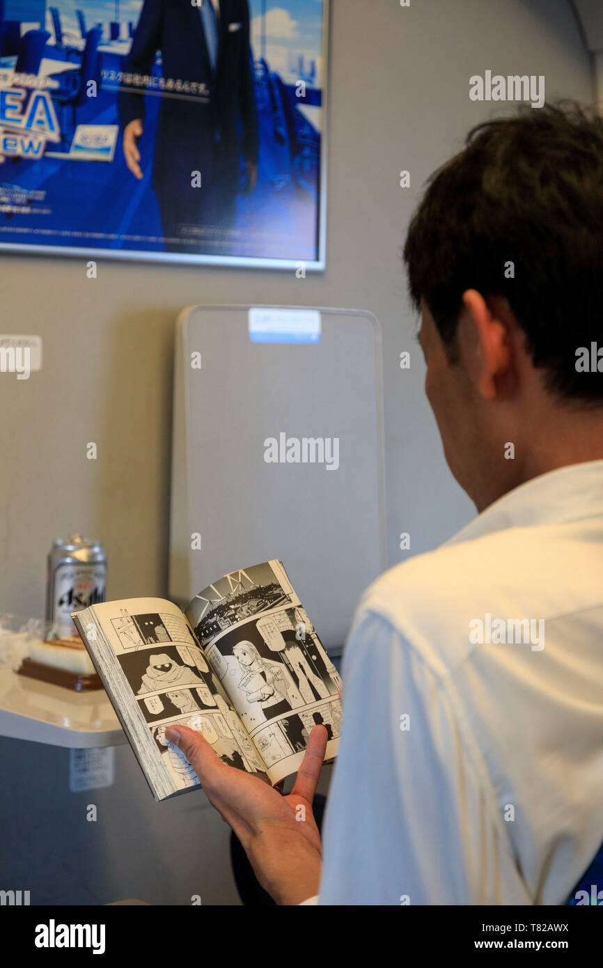 Giappone, isola di Honshu, Osaka, Stazione di Osaka, treno Shinkansen, manga player Foto Stock