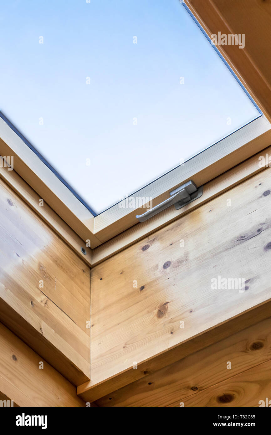 Finestra lucernario in casa di legno in soffitta. Camera con soffitto inclinato in materiali naturali con materiali ecologici. Ambiente casa. Foto Stock