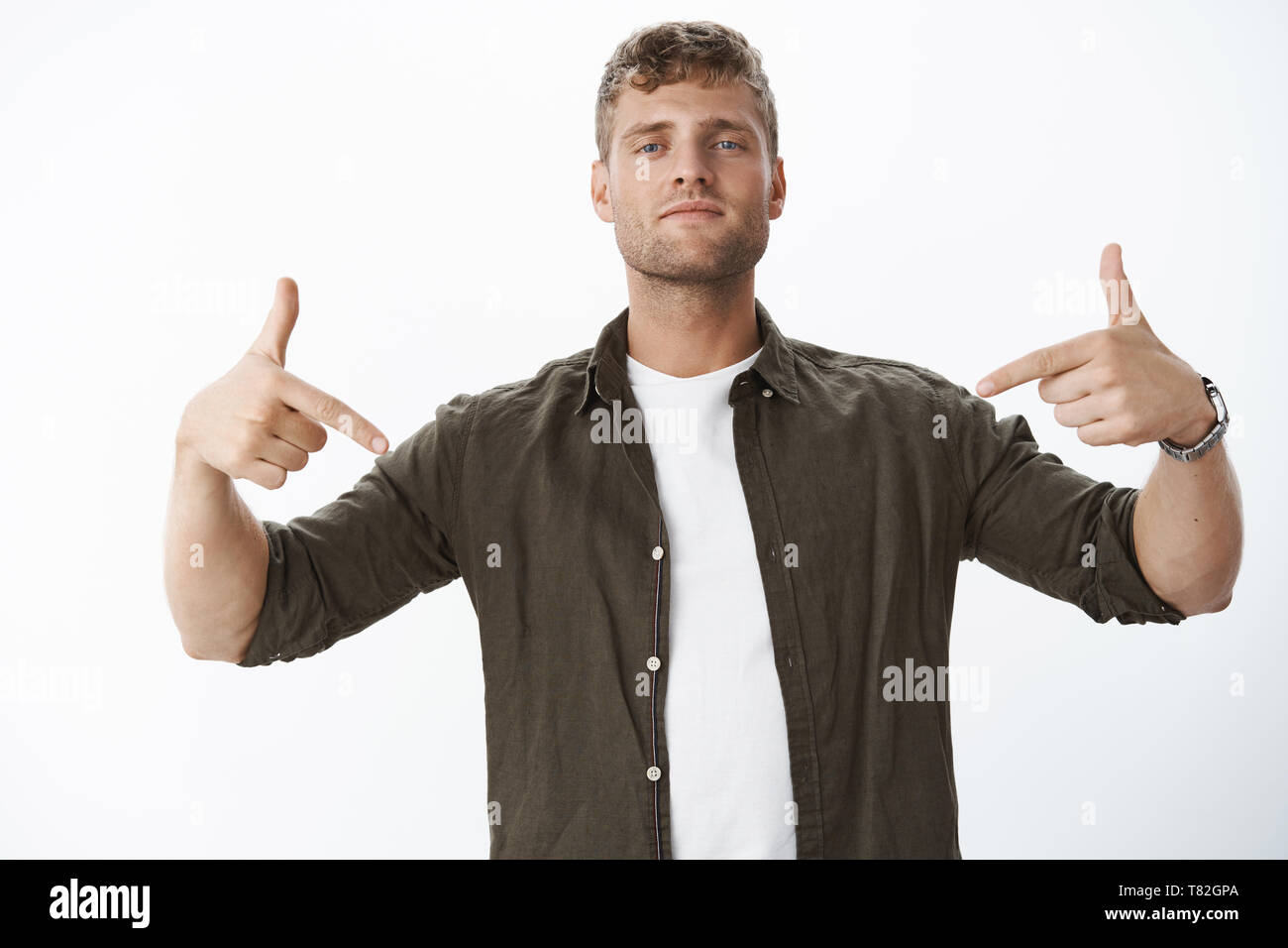 Uomo con lo sguardo fiducioso che ti dice a guardare incredibile promozione rivolta verso il basso con le dita indice cercando determinato e assertivo raccomandare Foto Stock