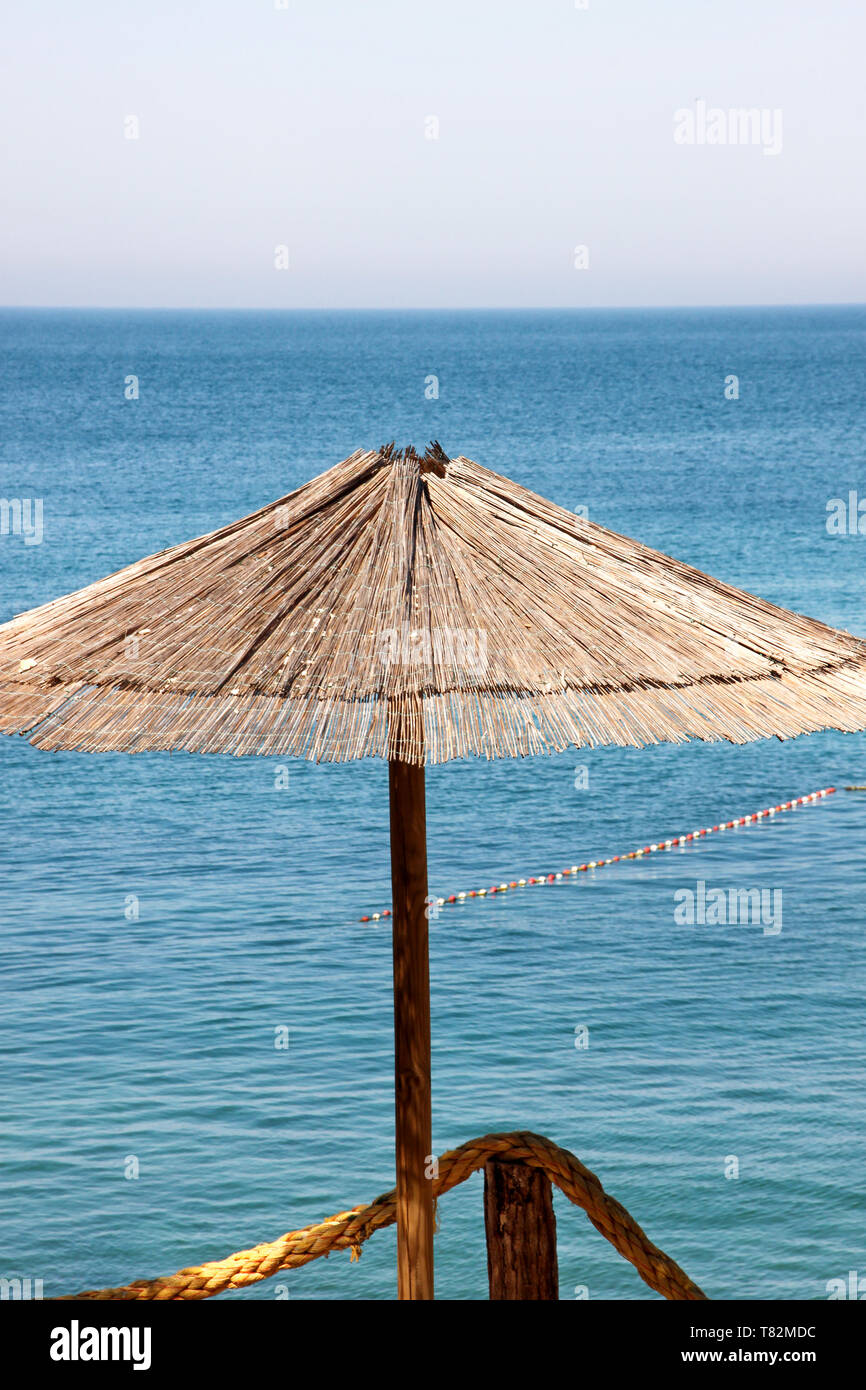 In vimini solitario ombrellone in spiaggia mediterranea dal mare. Bamboo  naturale di ombrelloni e l'estate Ombrello Ombrelloni sulla spiaggia  dell'oceano. Grandi ombrelloni da spiaggia Foto stock - Alamy