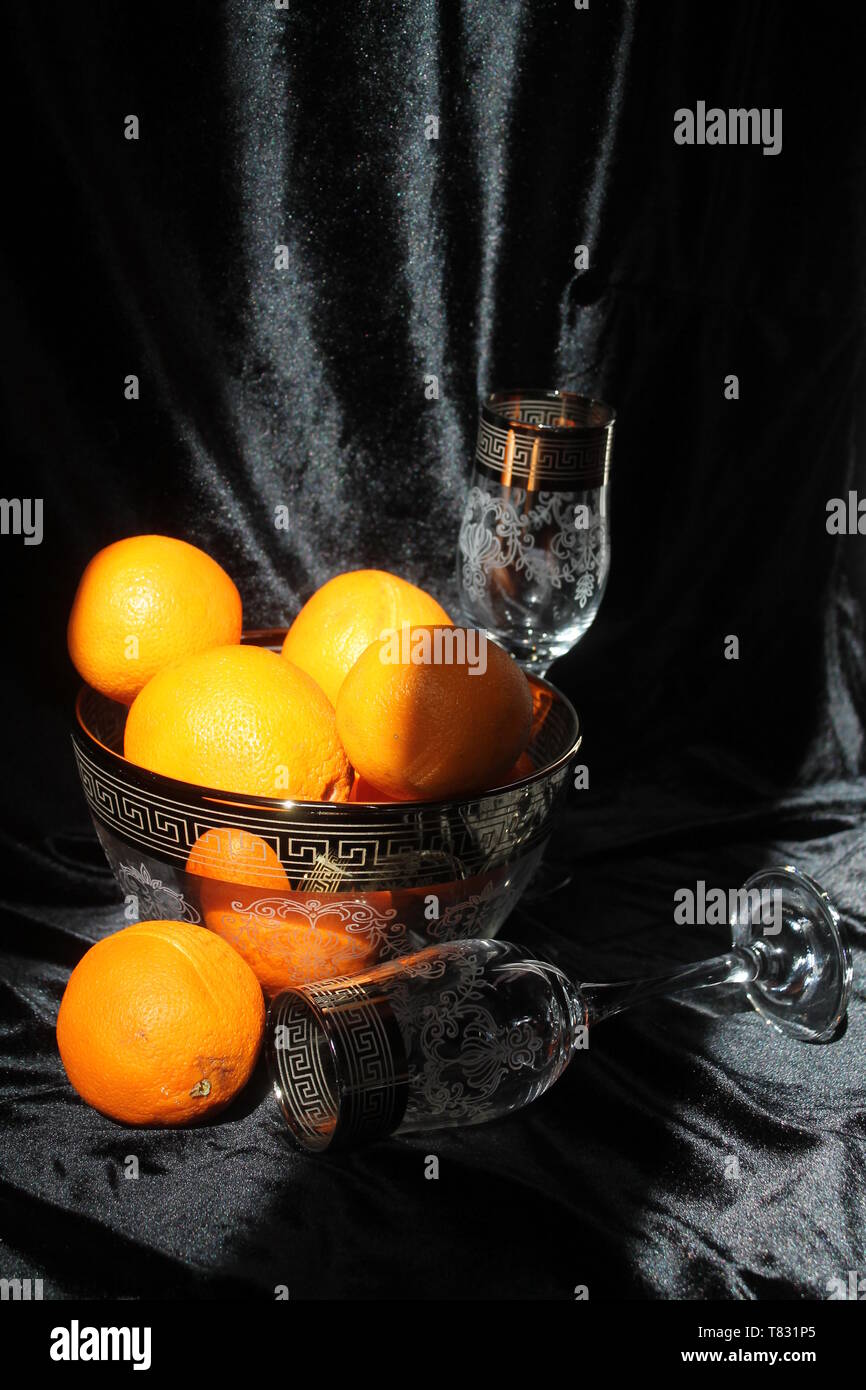 Bellissimo set di cristalli due bicchiere di vino con ciotola e succosa arancia fresca frutta per decorazione tavola in vacanza Foto Stock