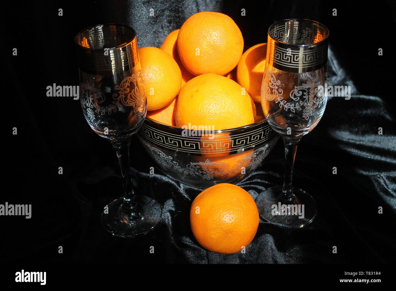 Bellissimo set di cristalli due bicchiere di vino con ciotola e succosa arancia fresca frutta per decorazione tavola in vacanza Foto Stock